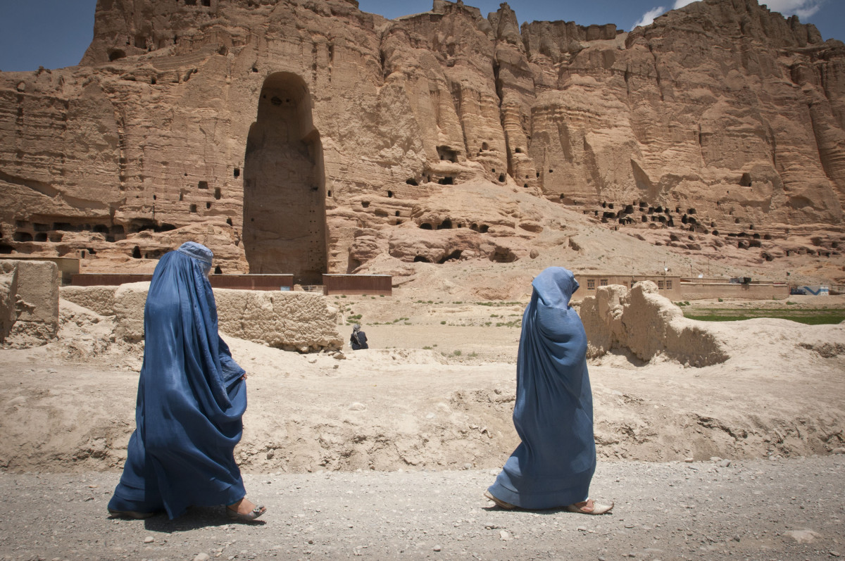 Deux femmes passent en burqa devant l'emplacement d'un des Bouddhas de Dâmiyân dynamités par les Talibans en 2001.
