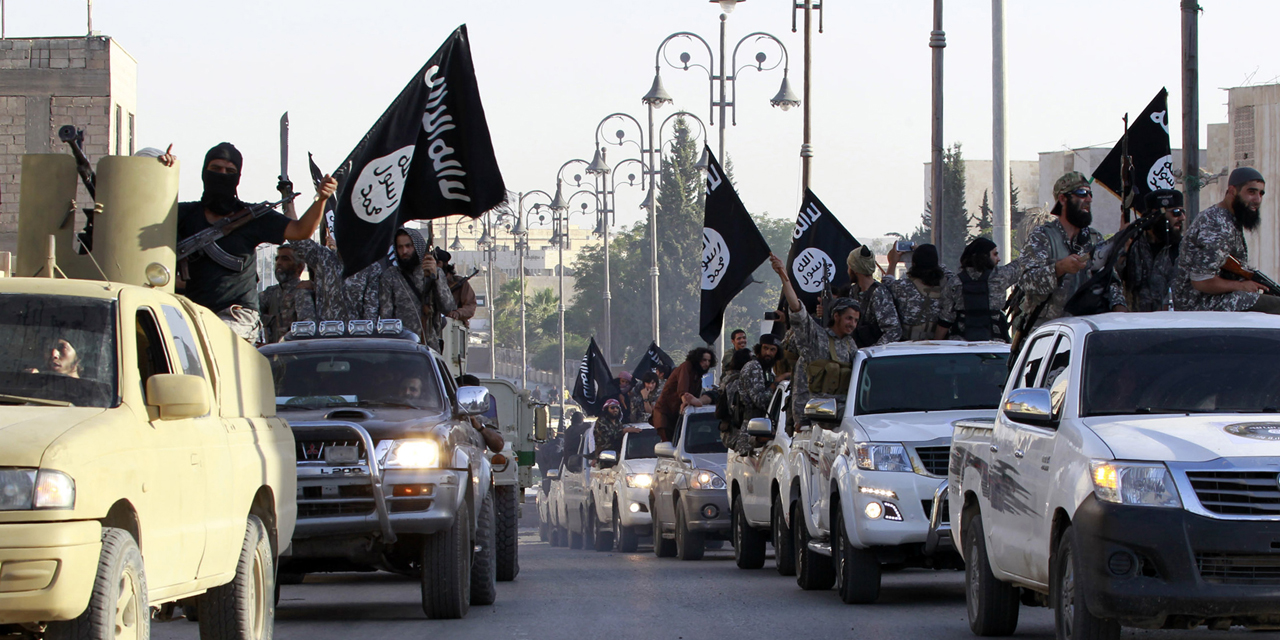 Militant Islamist fighters parade on military vehicles along the streets of northern Raqqa province June 30, 2014. Militant Islamist fighters held a parade in Syria's northern Raqqa province to celebrate their declaration of an Islamic "caliphate" after the group captured territory in neighbouring Iraq, a monitoring service said. The Islamic State, an al Qaeda offshoot previously known as Islamic State in Iraq and the Levant (ISIL), posted pictures online on Sunday of people waving black flags from cars and holding guns in the air, the SITE monitoring service said. REUTERS/Stringer (SYRIA - Tags: POLITICS CIVIL UNREST CONFLICT)  FOR BEST QUALITY IMAGE ALSO SEE: GF2EA99110K01 - RTR3WJAI